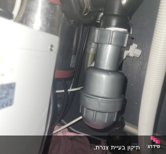 צנרת מתחת לכיור עם מגבת ורודה
